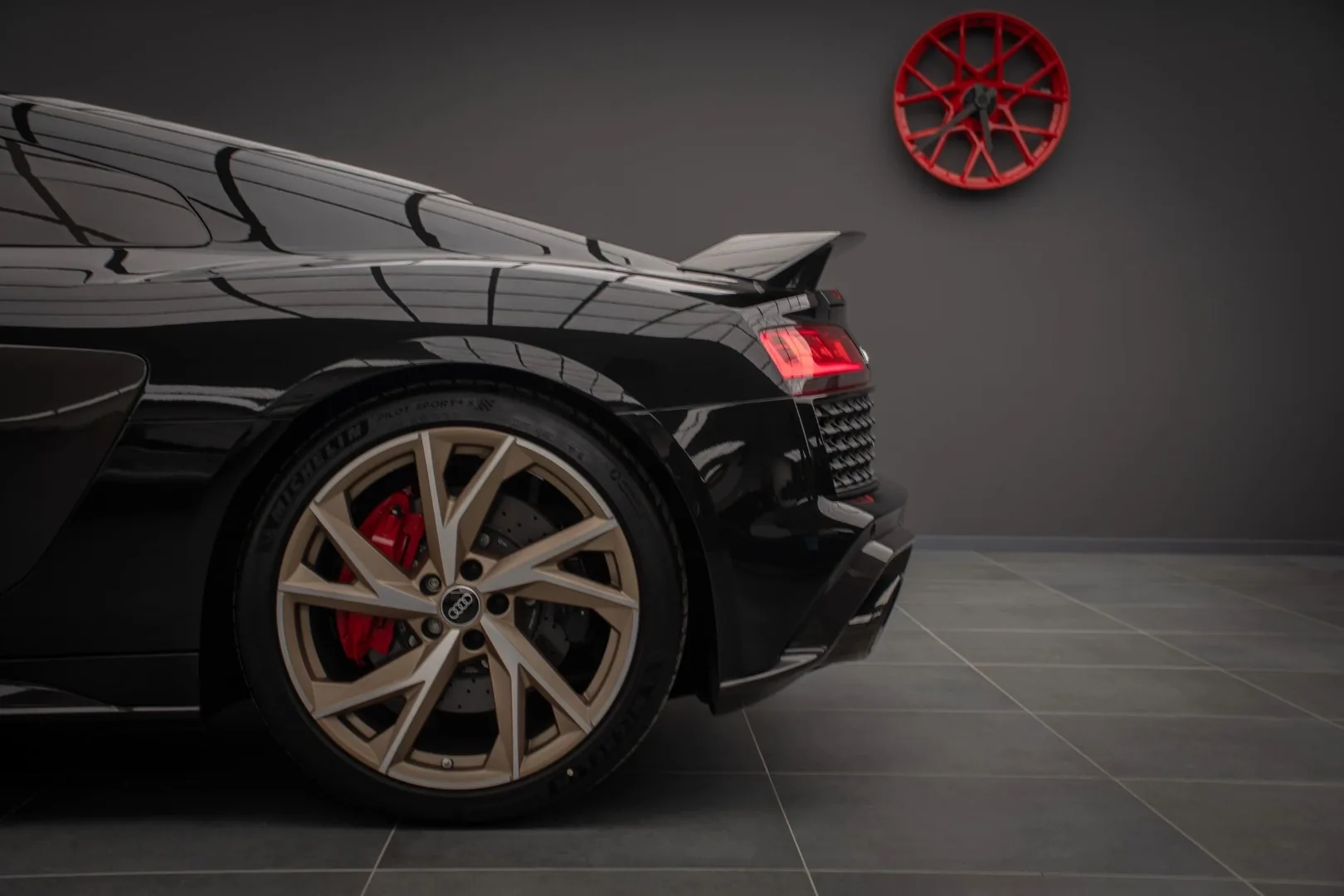 Audi R8 V10 rear quarter view with bronze wheels and red brake calipers