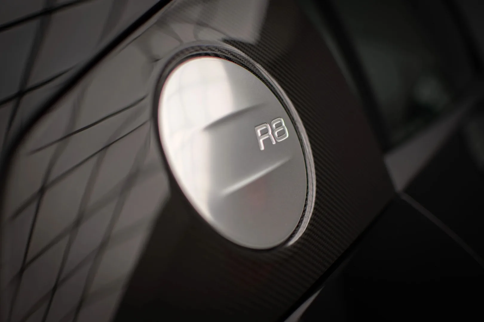 Audi R8 fuel cap with engraved R8 logo on carbon fiber sideblade