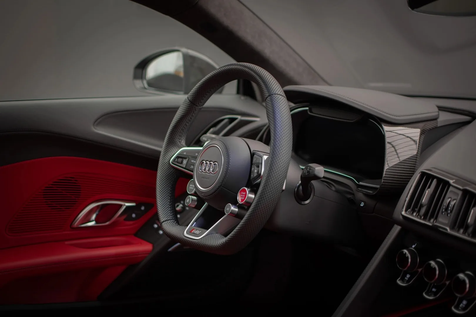 Audi R8 V10 interior cockpit with red Alcantara dashboard and flat-bottom steering wheel