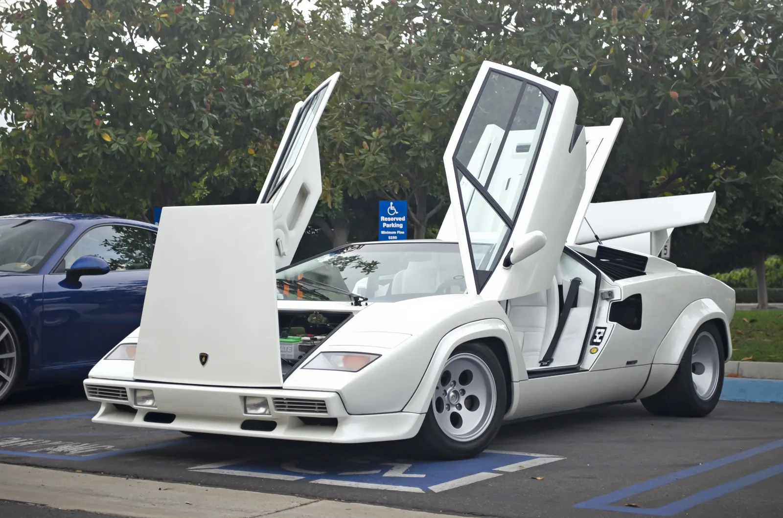 White Lamborghini Countach 5000 Quattrovalvole front three-quarter with boxed wheel arches, NACA side intakes and a large rear wing