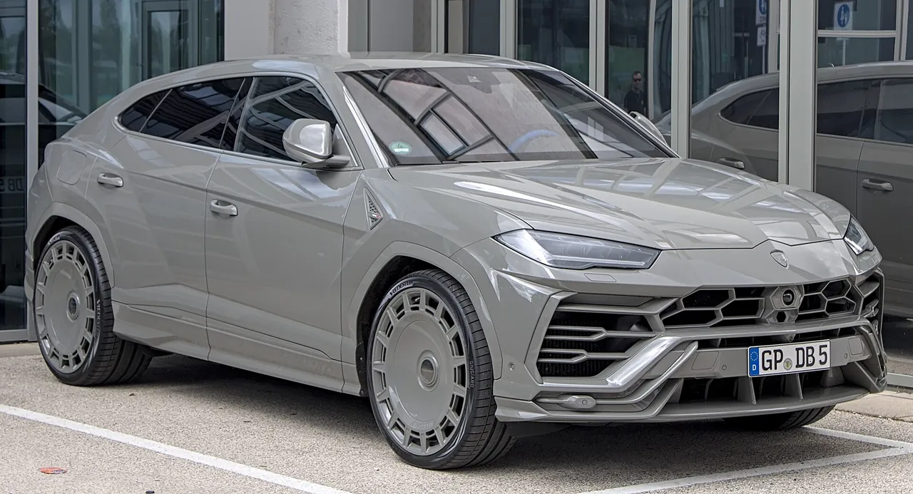 Grey Lamborghini Urus with Mansory body kit and black wheels, front three-quarter view