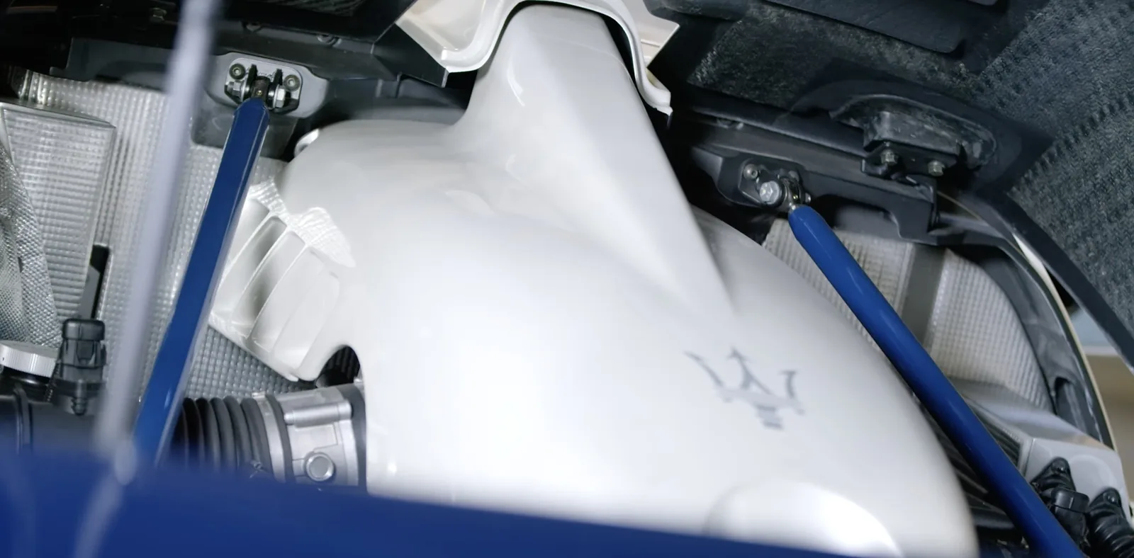 Engine bay of the Maserati MC12 Stradale with the white intake plenum of the 6.0-litre V12 and Maserati trident marking