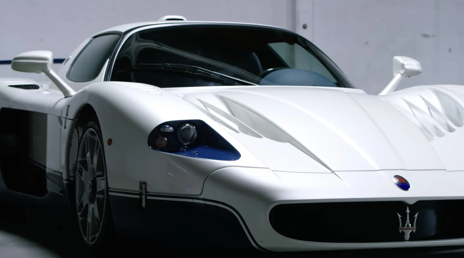 Front detail of the Maserati MC12 Stradale with blue-backed headlight, louvred bonnet vents and Maserati trident badge