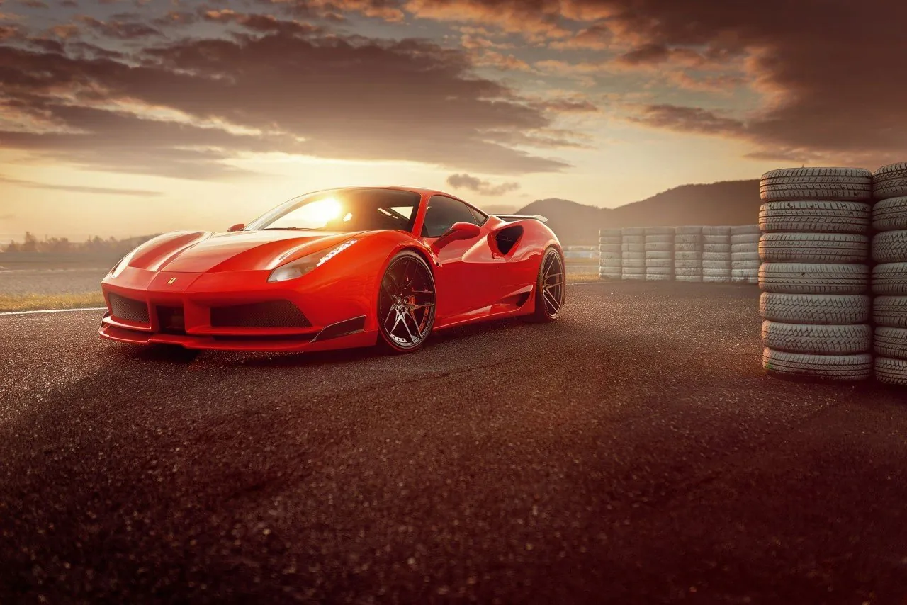 Red Novitec Ferrari 488 N-Largo widebody at sunset next to stacked tyres