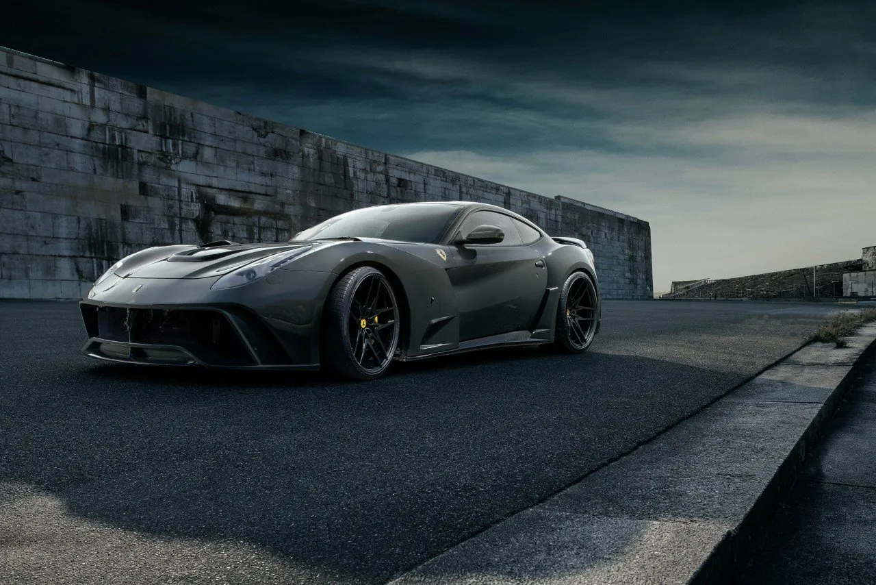 Grey Novitec Ferrari F12 N-Largo S widebody, front three-quarter view by a concrete wall
