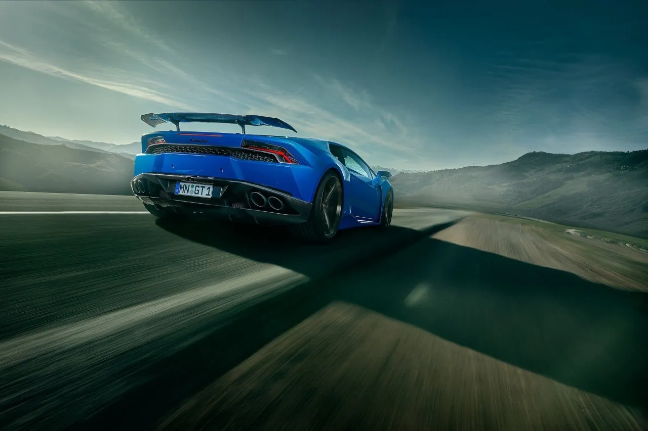 Blue Novitec Lamborghini Huracan N-Largo driving, rear three-quarter view with fixed rear wing