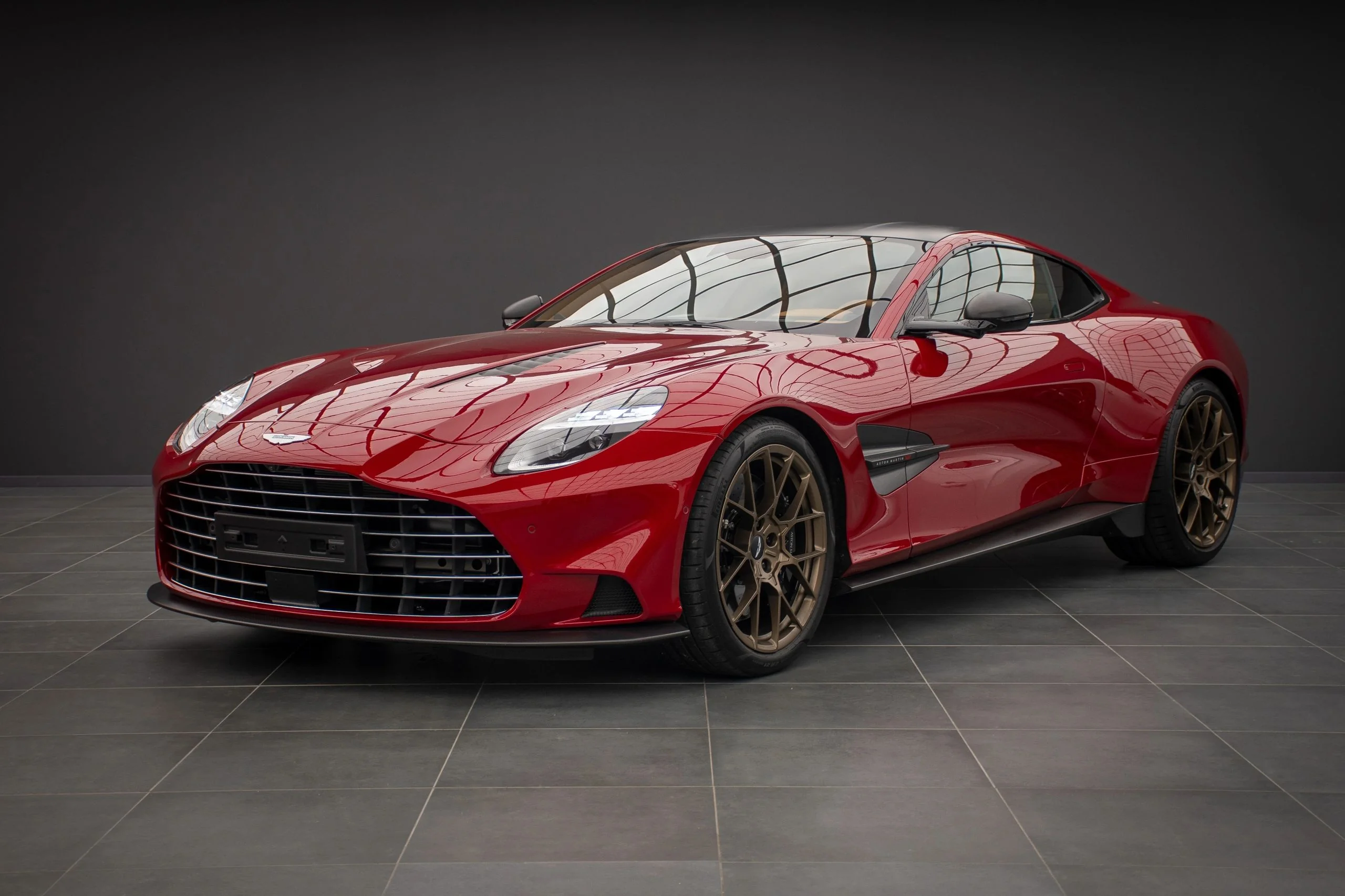 Aston Martin DB12 in red with bronze wheels at Batman Garage