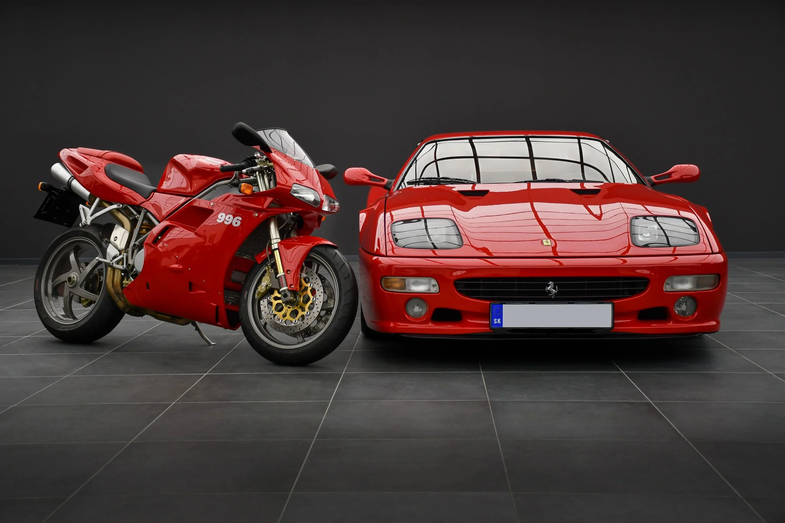 Red Ducati 996 superbike and Ferrari 512M Testarossa in Batman Garage