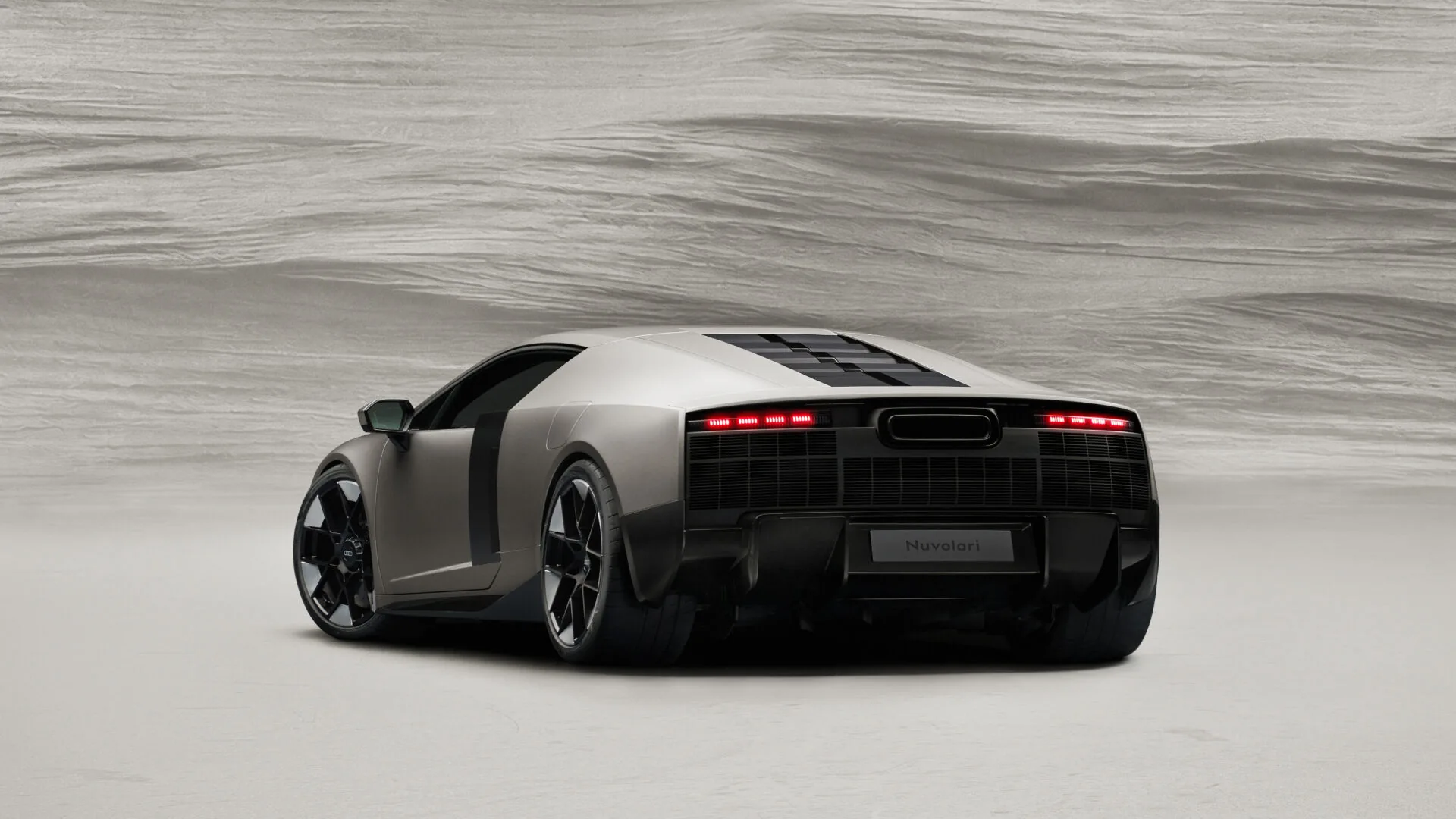 Audi Nuvolari 2027 rear three-quarter side view in Titanium colour with deployable rear wing &mdash; 1,001 PS V8 biturbo plug-in hybrid supercar revealed at Audi Summit in Antibes on June 4, 2026
