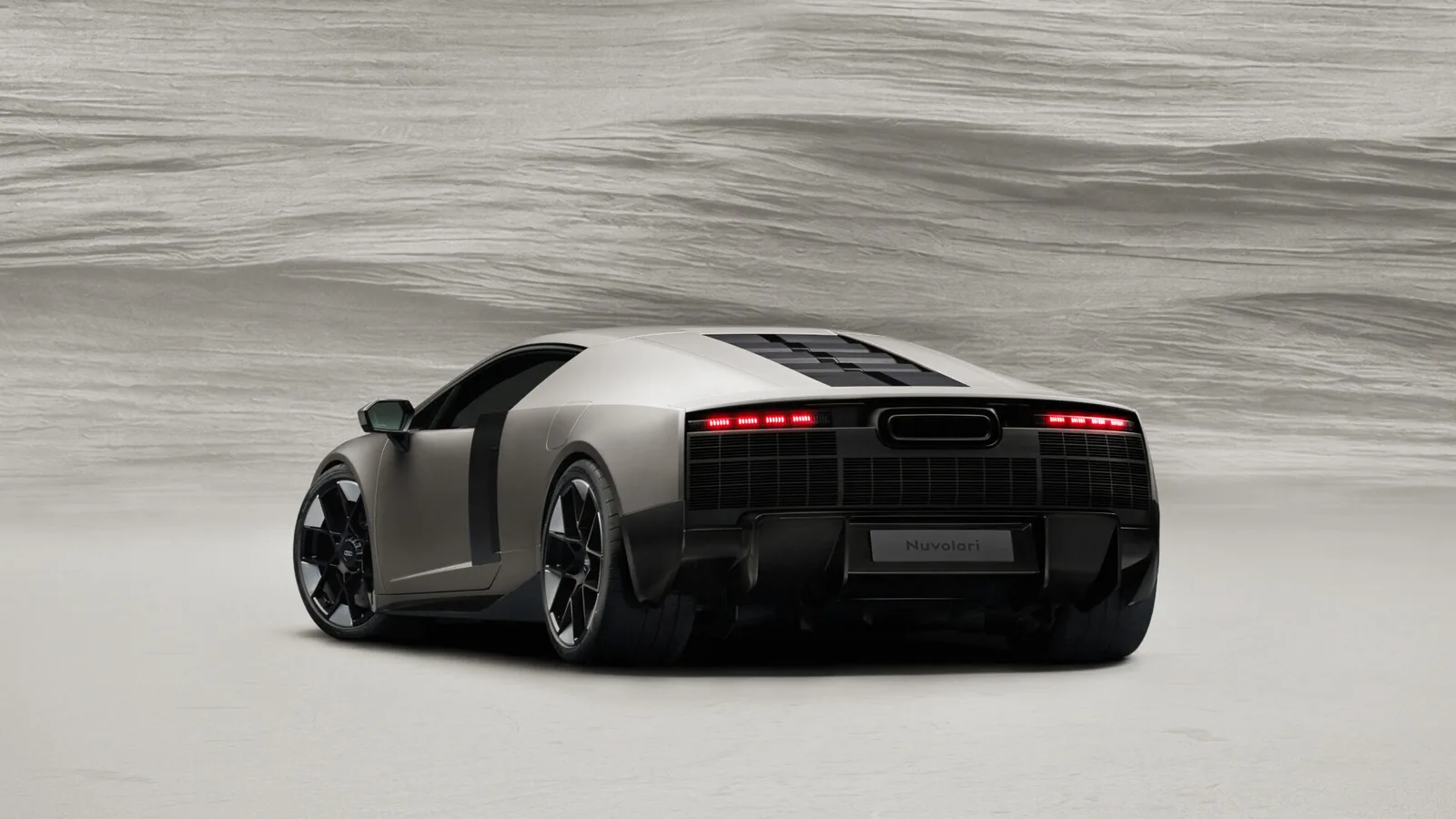 Audi Nuvolari 2027 rear three-quarter — deployable carbon rear wing with integrated four rings logo, dual exhaust outlets