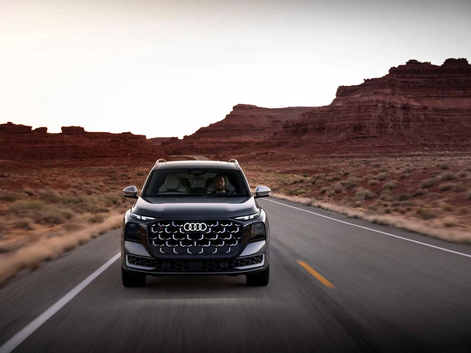 2027 Audi SQ9 front head-on driving in Utah canyon — hexagonal honeycomb grille and split matrix LED headlights