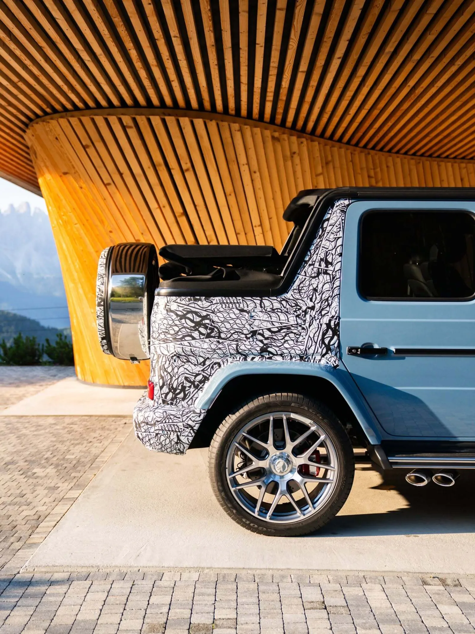 Mercedes-AMG G63 Cabriolet top-down view revealing the folded canvas roof stacked behind the second row and the fixed metal roof section above the front seats