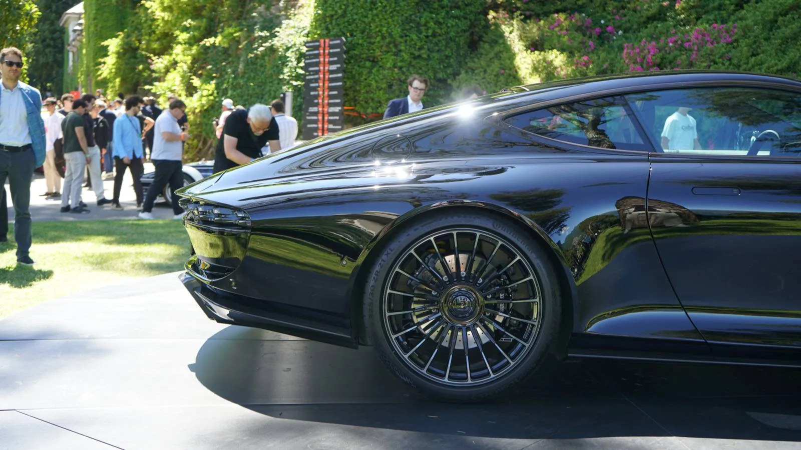 Brabus Bodo rear three-quarter view at FuoriConcorso 2026 — electrically deployable two-stage active rear spoiler, exposed carbon trunk lid, four stacked titanium tailpipes