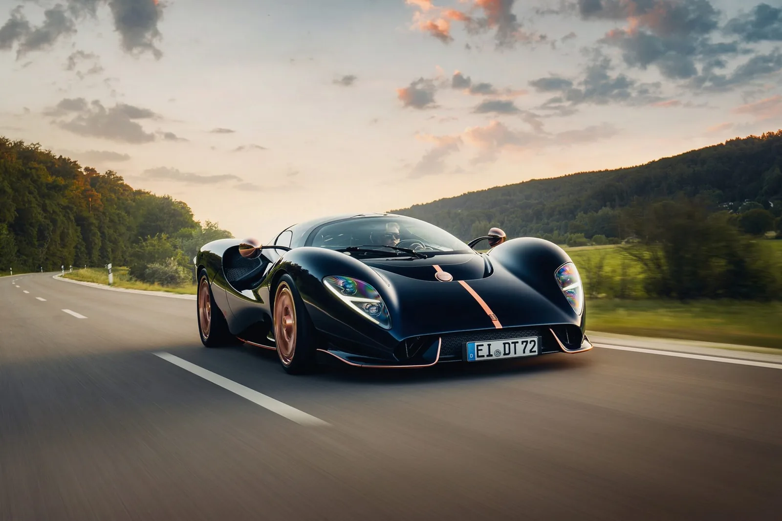 De Tomaso P72 Aurelian Night in midnight blue with rose gold stripe driving on a country road, German EI DT 72 registration plate