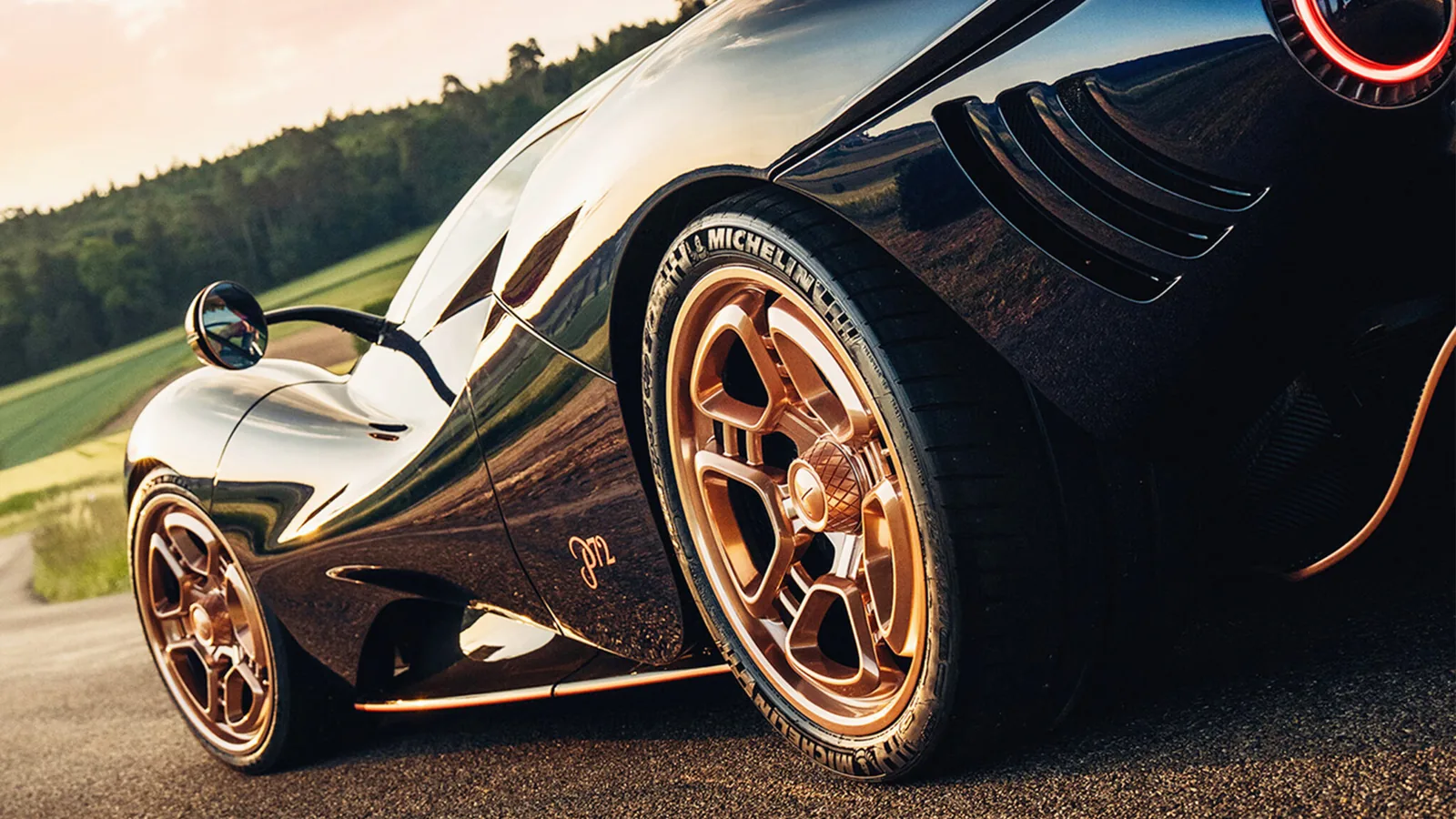 De Tomaso P72 Aurelian Night low angle detail of rose gold centre-lock wheel and P72 script at sunset