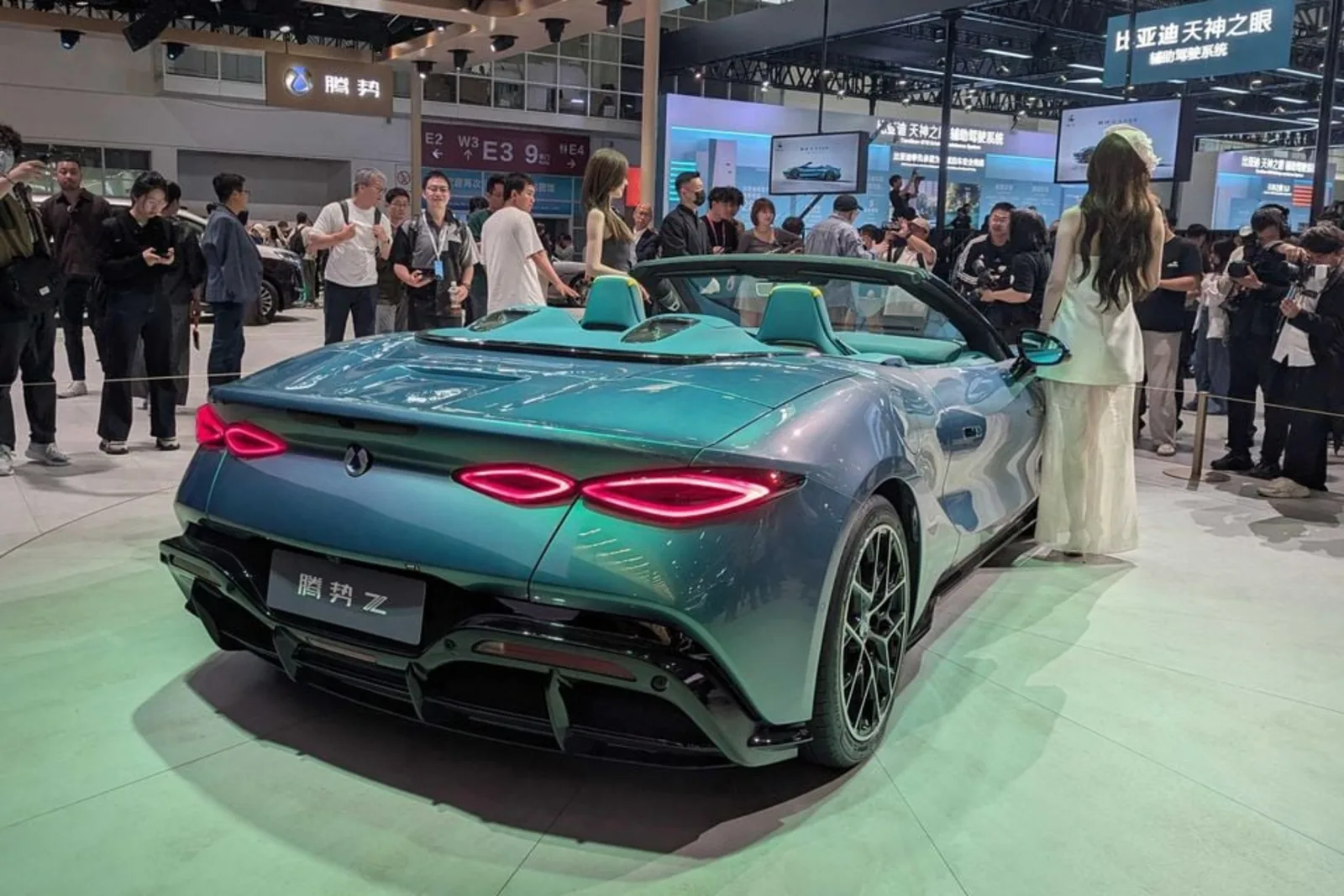 Denza Z Convertible rear three-quarter at the Beijing Auto Show 2026 with illuminated taillights and twin headrests visible behind the dual cockpit