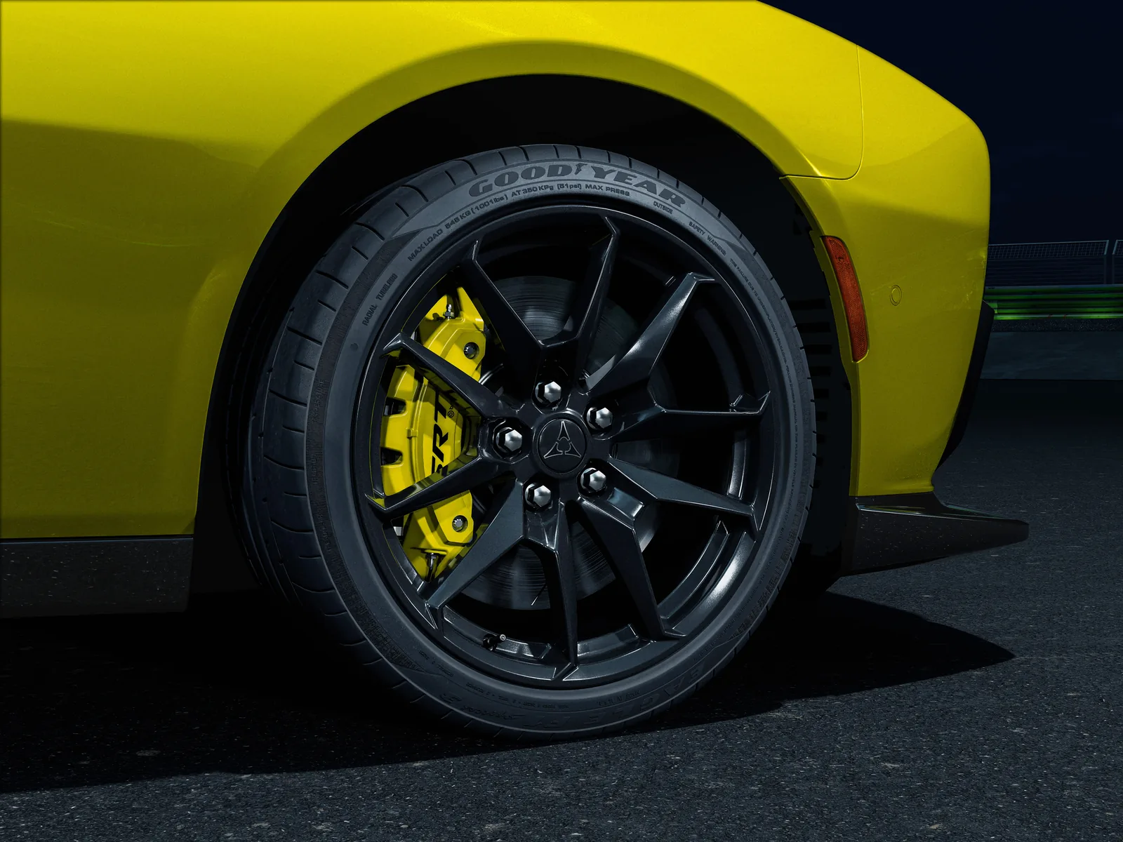 2027 Dodge Charger Super Bee wheel and brake close-up &mdash; 20-by-11-inch forged gloss-black wheel with Hyper Lime six-piston Brembo caliper