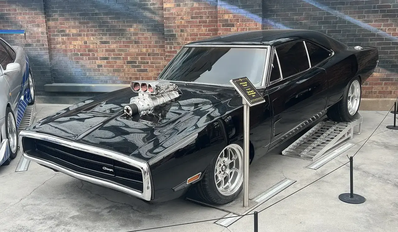 Black 1970 Dodge Charger R/T with exposed blower as Dom Toretto drives it in The Fast and the Furious, displayed at Universal Studios Hollywood