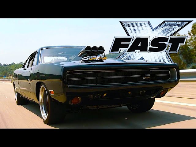 Black Dodge Charger driving on a highway beneath a Fast X title graphic
