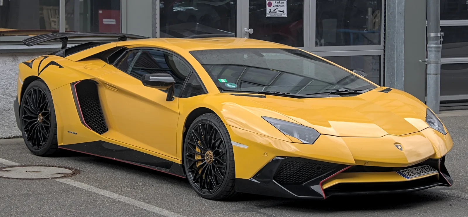 Lamborghini Aventador LP750-4 Superveloce in yellow with black wheels, side profile view showing the fixed carbon rear wing, extended side skirts and enlarged front air intakes