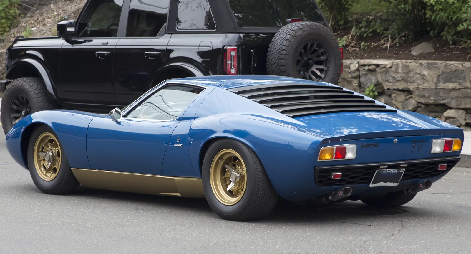 Lamborghini Miura P400 SV in Blu Medio, rear three-quarter view showing the widened rear bodywork, gold Campagnolo wheels and slatted engine cover of the Super Veloce