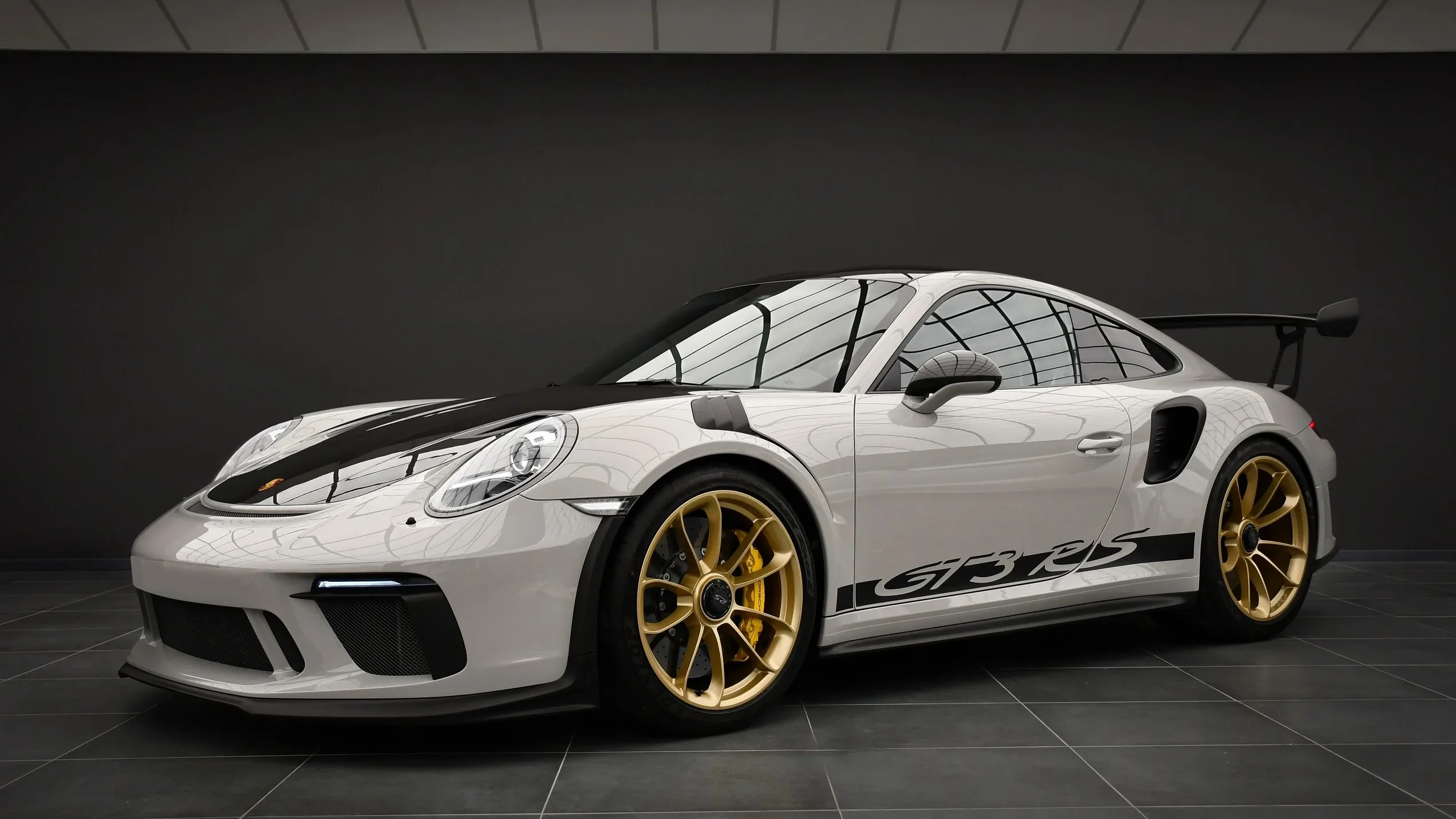 Porsche 911 GT3 RS 991.2 Weissach in chalk white with gold center-lock wheels, front three-quarter in the Batman Garage studio