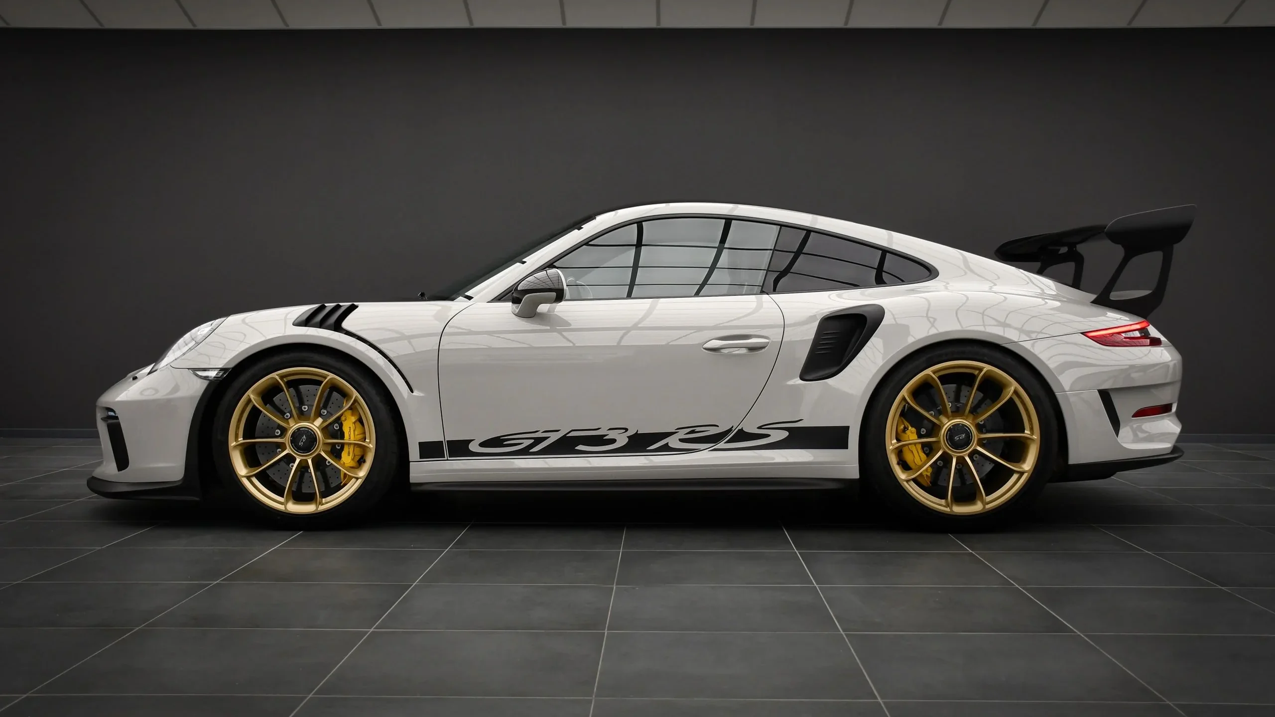 Porsche 911 GT3 RS 991.2 Weissach side profile in chalk white with gold wheels in the Batman Garage studio