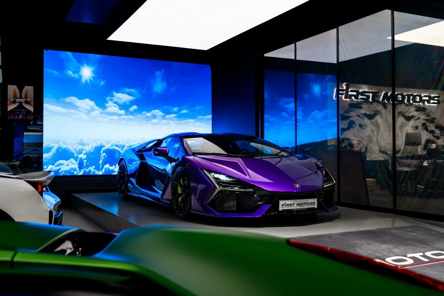 Lamborghini Revuelto in Viola purple parked at F1rst Motors Dubai showroom below the F1RST MOTORS wall wordmark
