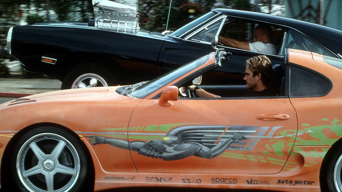 Rear three-quarter view of the orange Supra with APR biplane wing