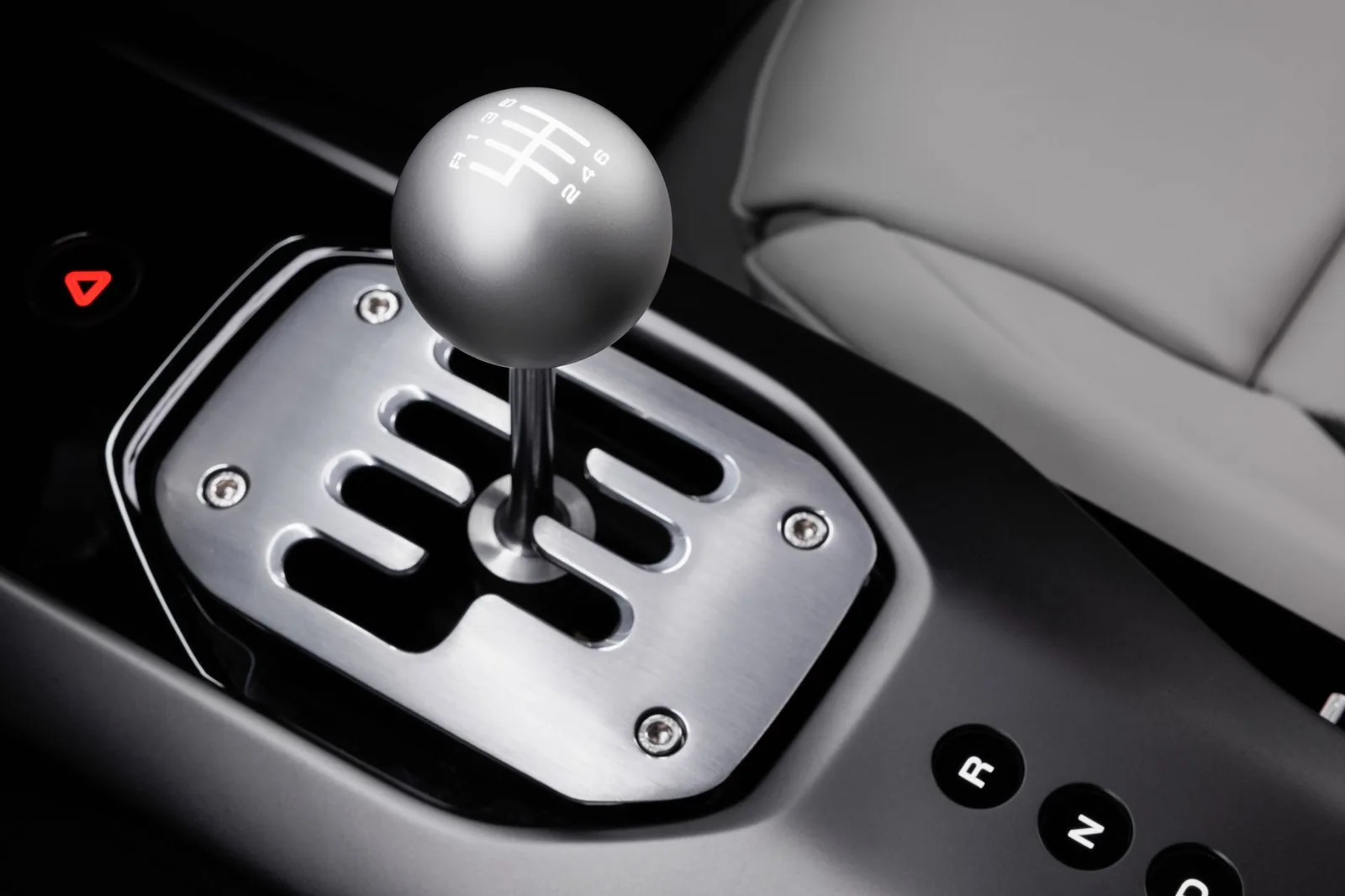 Ferrari 12Cilindri Manuale gated shifter close-up — brushed aluminium gate with 6-speed pattern and R123D 246 numerals