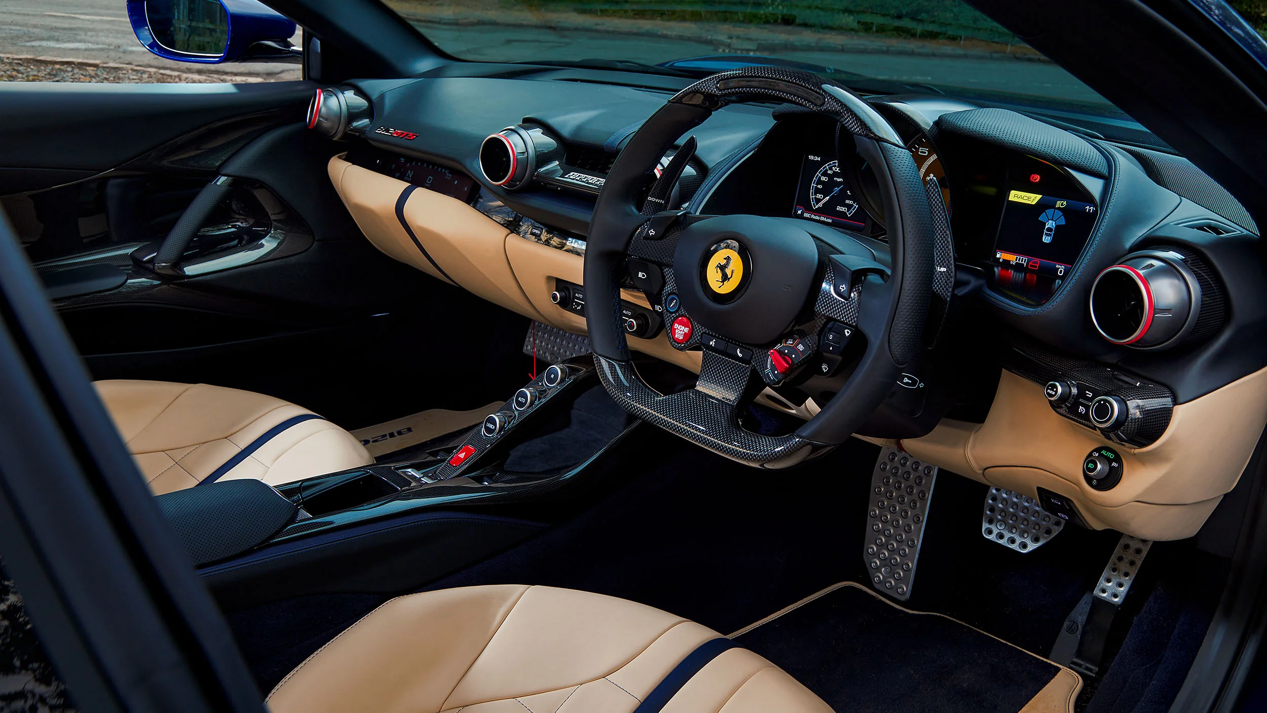 Ferrari 812 GTS red ENGINE START STOP button on carbon fiber steering wheel with Manettino driving mode selector
