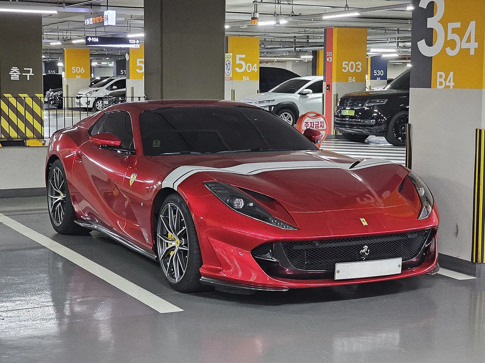 Red Ferrari 812 GTS in Rosso with the roof open, front three-quarter view of the V12 convertible
