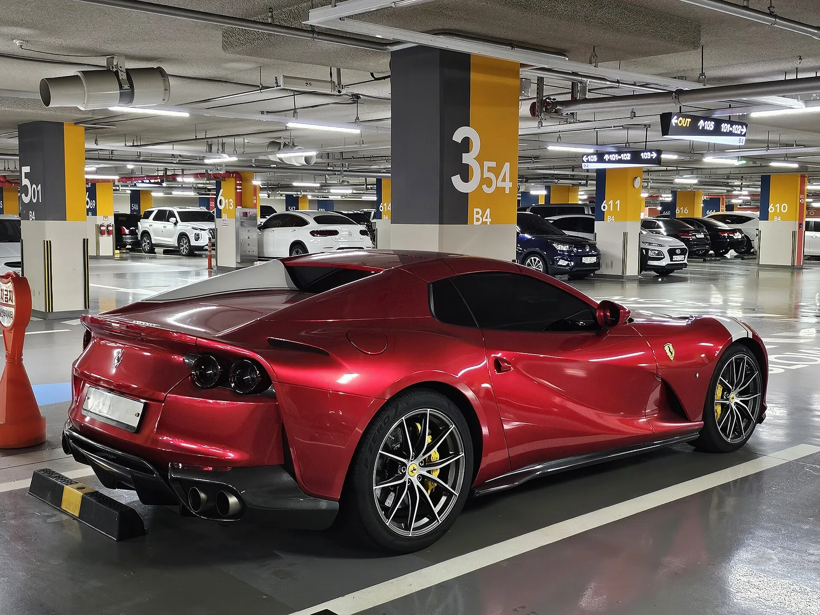 Red Ferrari 812 GTS rear three-quarter showing the V12 grand tourer proportions