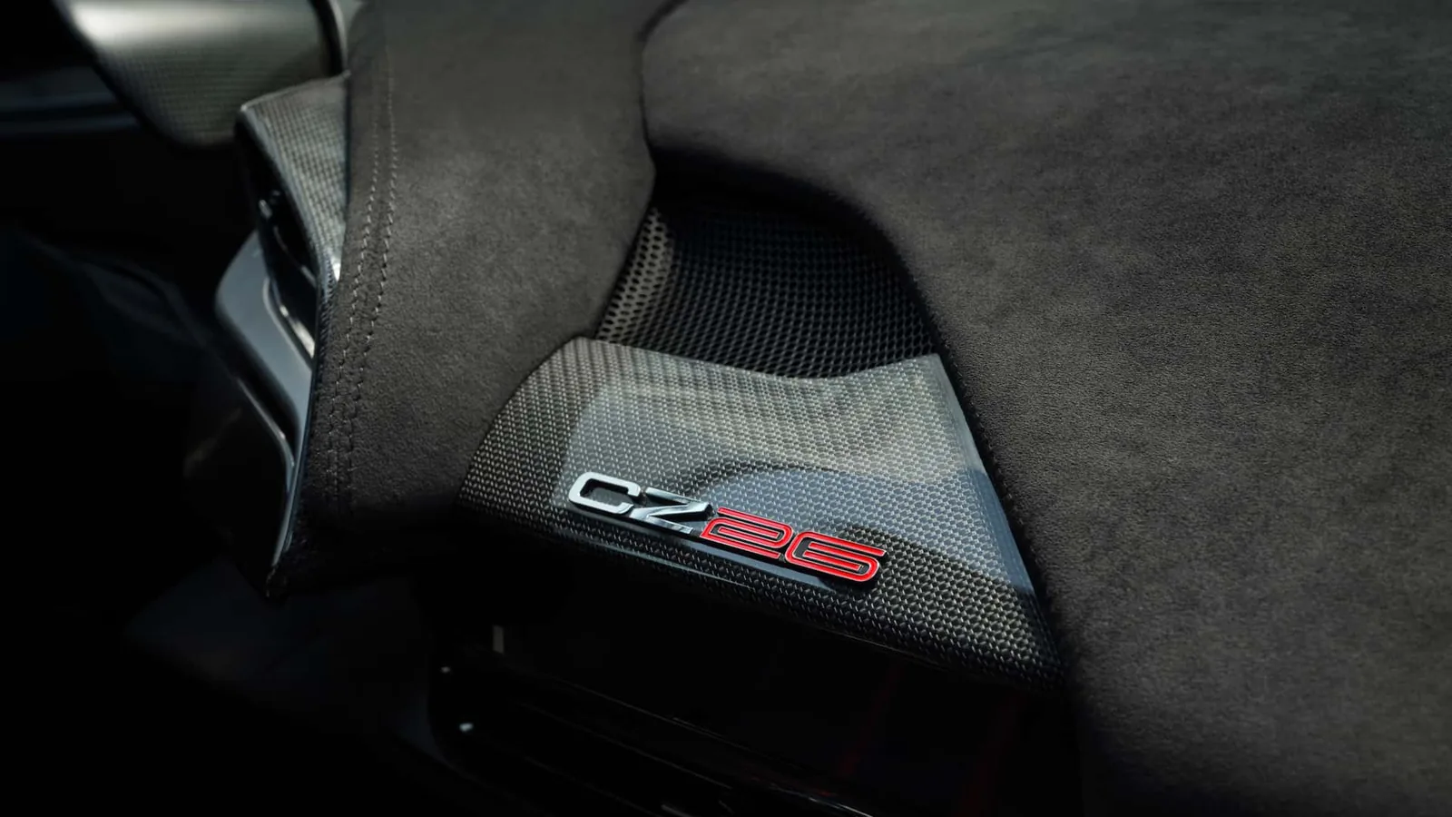Ferrari CZ26 door panel detail with red CZ26 badge on gloss carbon fibre and black technical fabric