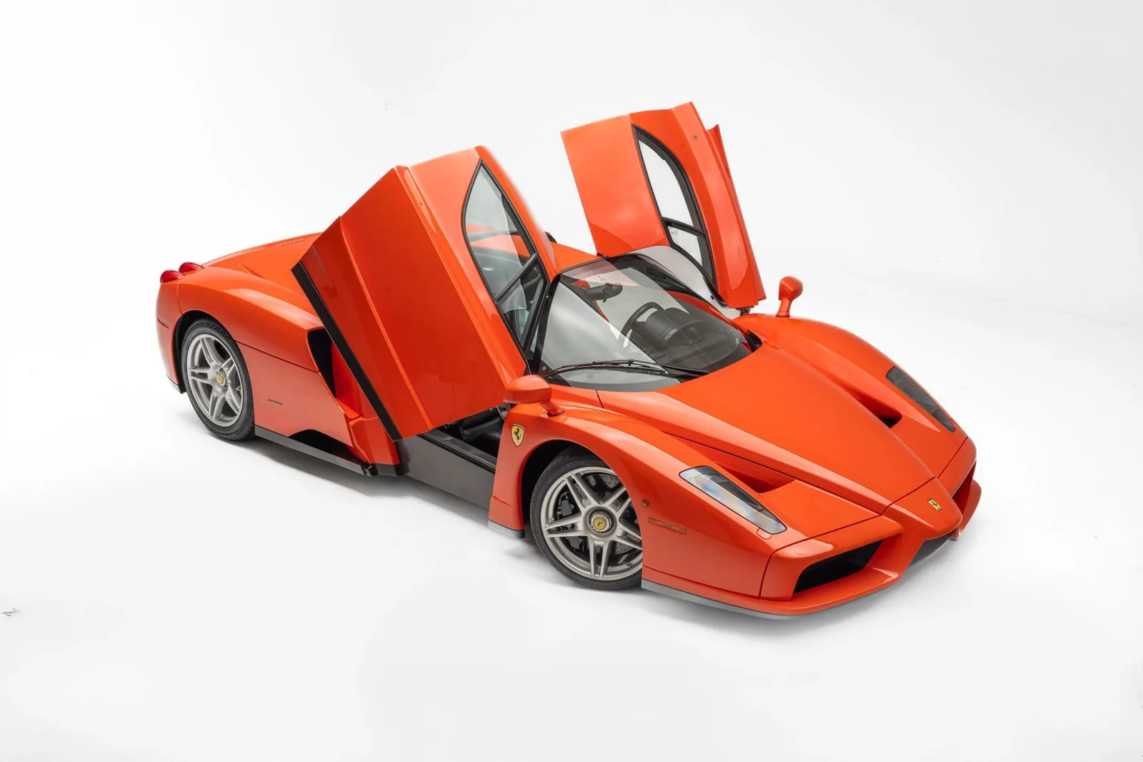 Ferrari Enzo in Rosso Dino front view showing the F1-derived nose, fixed headlights and carbon-fiber bodywork in the unique orange-red shade