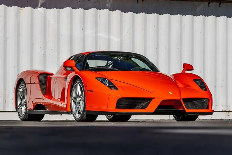Ferrari Enzo Rosso Dino rear three-quarter view with the active rear spoiler, quad taillights and exposed V12 engine bay