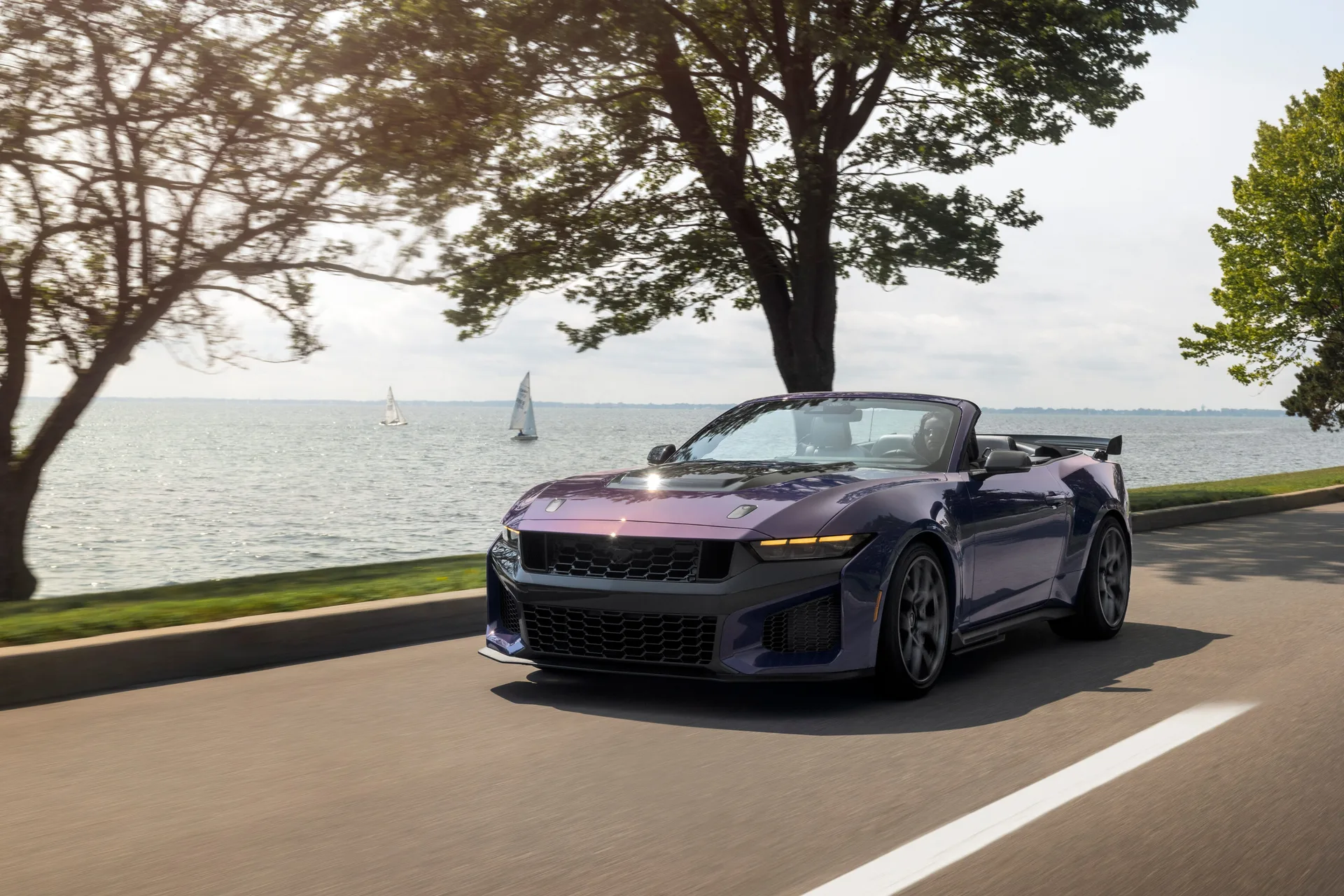 2027 Ford Mustang Dark Horse SC Convertible in Precision Purple driving lakeside with sailboats in the background at Woodward Dream Cruise 2026 debut