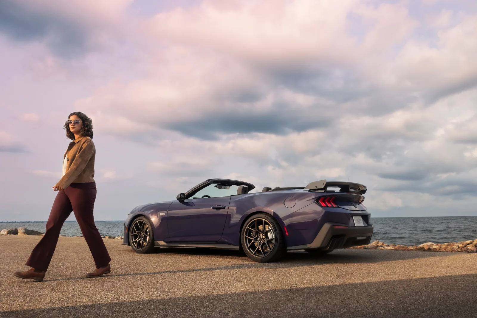 2027 Ford Mustang Dark Horse SC Convertible rear three-quarter with roof lowered, lifestyle scene at Woodward Dream Cruise 2026 debut, Precision Purple paint