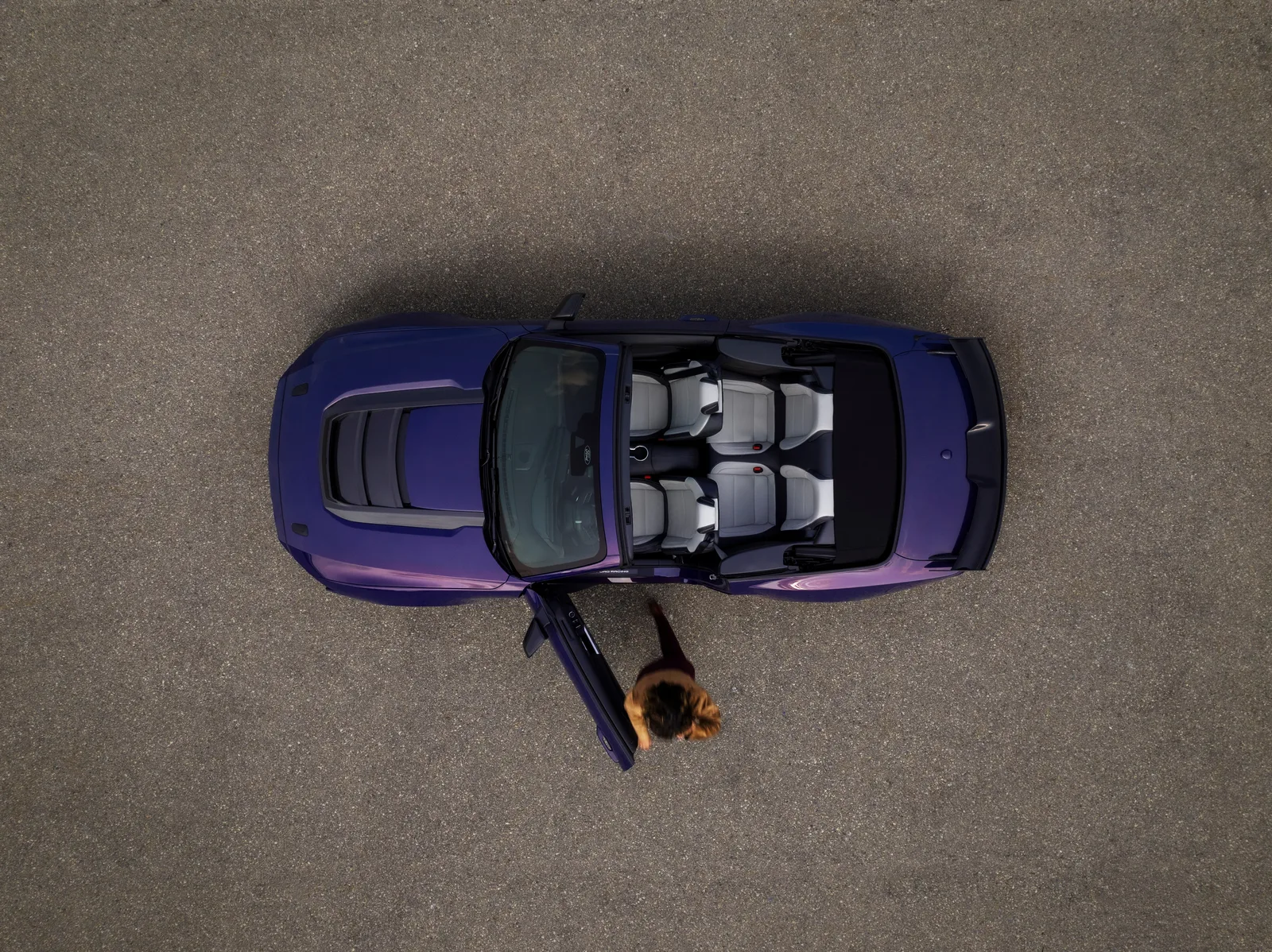 Aerial top-down view of the 2027 Ford Mustang Dark Horse SC Convertible in Precision Purple parked on lakeside stone paving with roof lowered, showing bespoke Dark Horse SC bonnet vents and full cabin layout