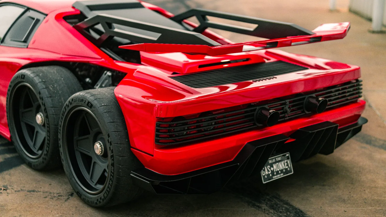 Gas Monkey Ferrari F6 rear three-quarter view showing the two rear axles, four wheels and a large chassis-mounted rear wing