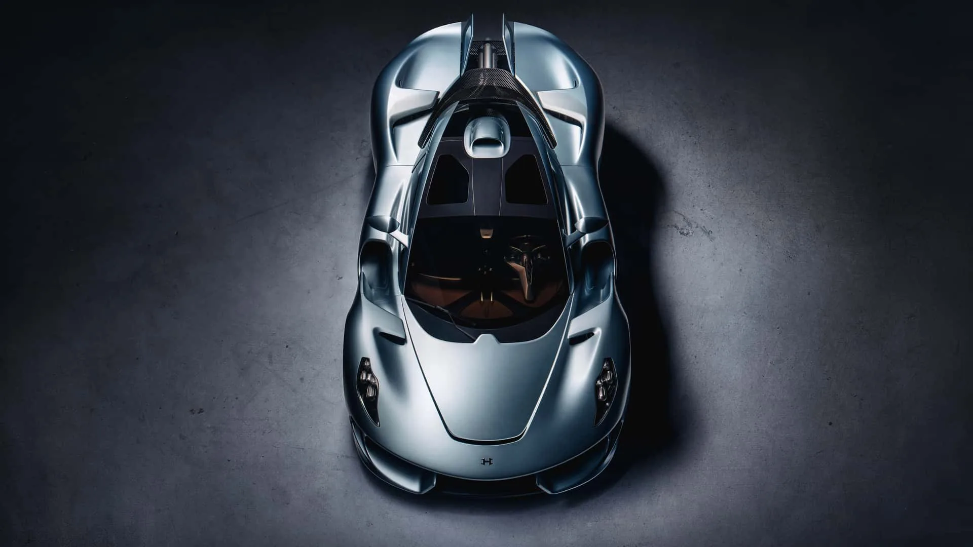 Hennessey Blackbird cockpit top-down &mdash; two-tone tan leather and exposed carbon-fibre seats, screen-free dash, gated shifter