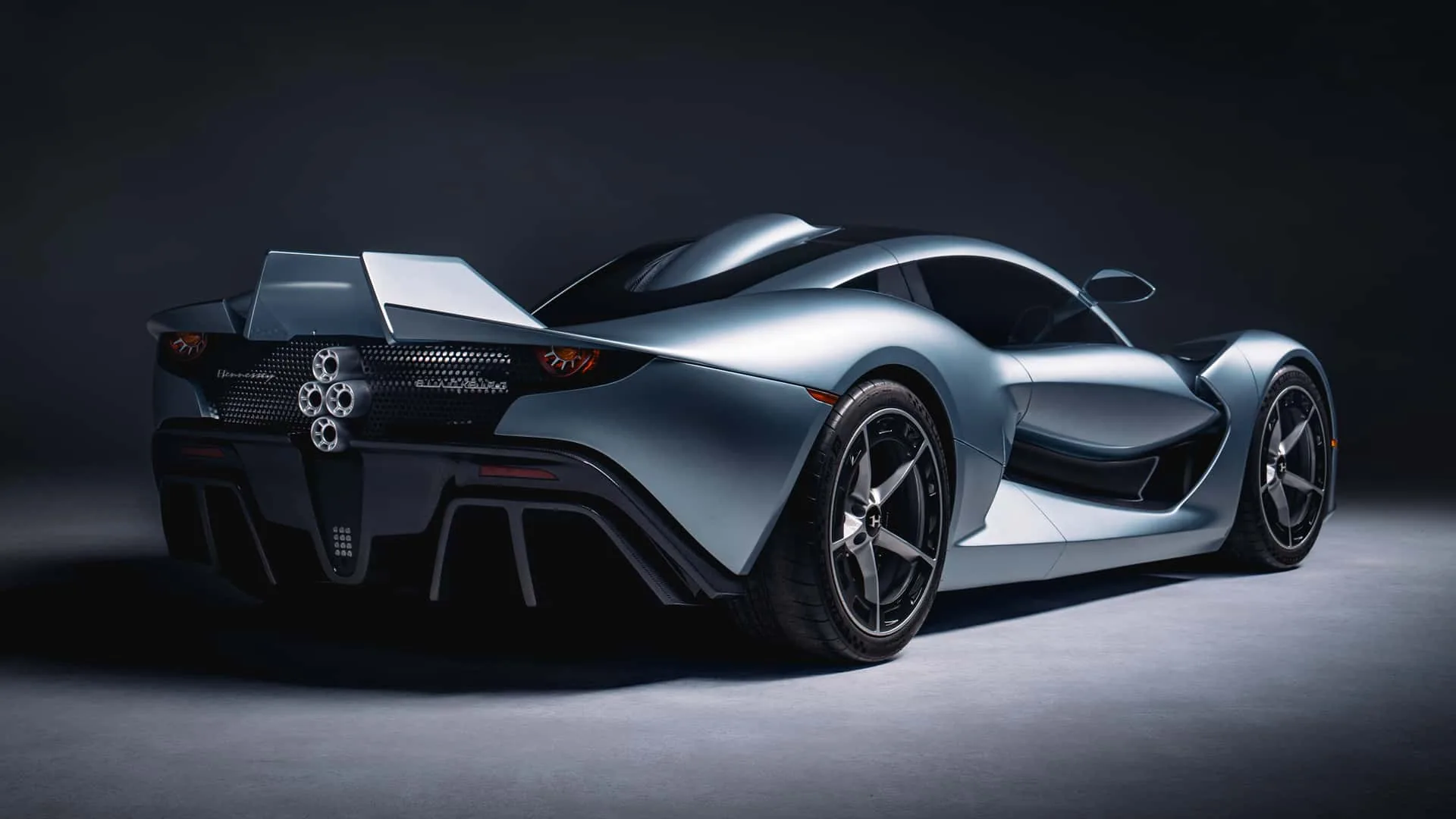 Hennessey Blackbird rear three-quarter studio shot &mdash; vertical stabilizer tail fins, flying-buttress rear deck, diamond quad exhaust and six-piston brakes