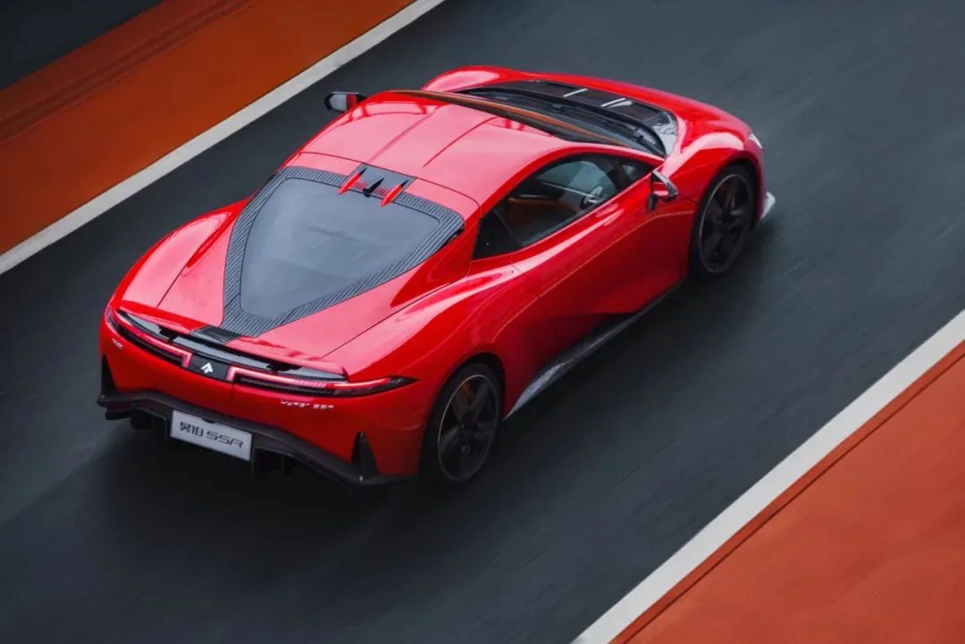 Red Hyptec SSR driving on a race track, rear three-quarter view from above