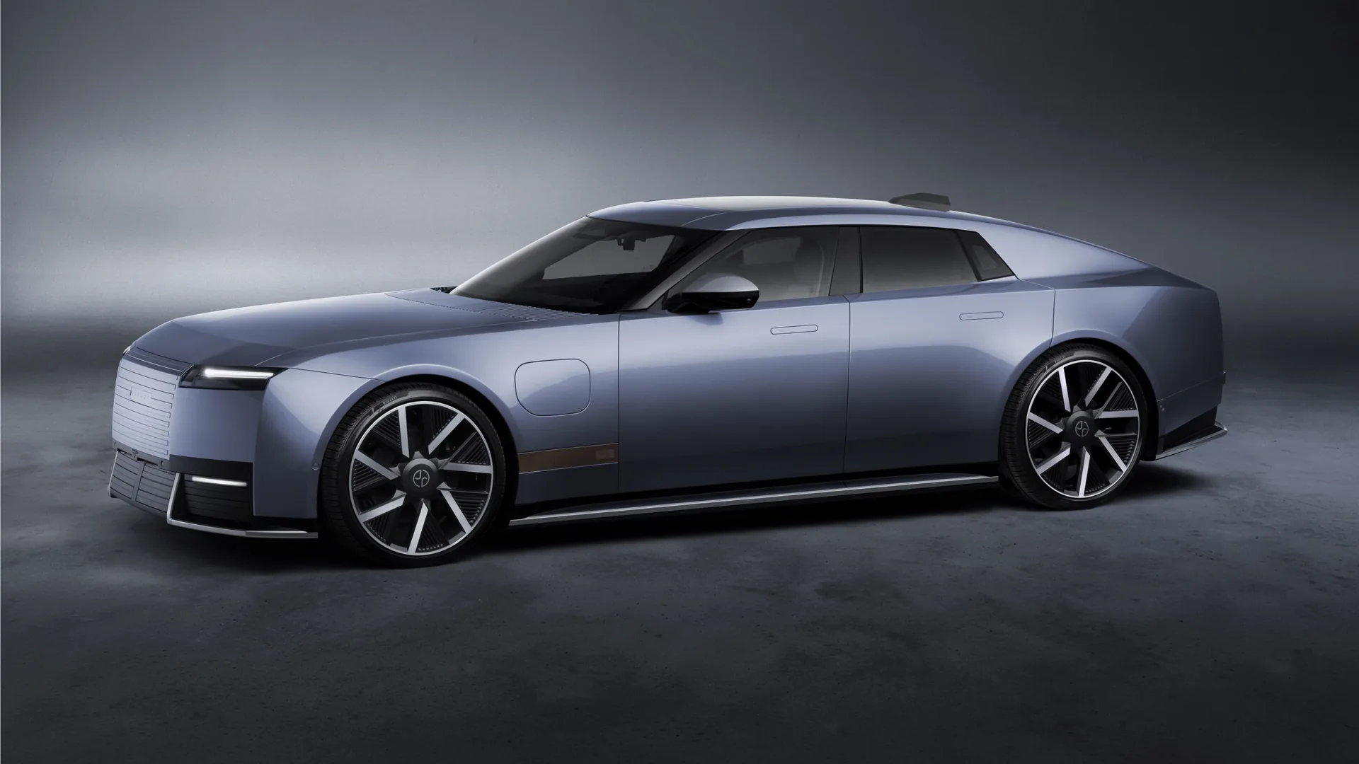 Jaguar Type 01 electric four-door GT in blue-grey, front three-quarter side view in a grey studio