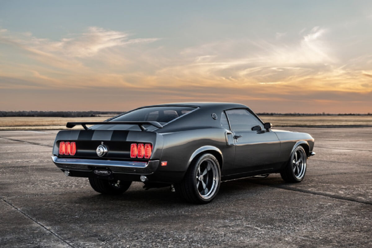 Dark gray John Wick-style 1969 Ford Mustang viewed from the rear three-quarter angle