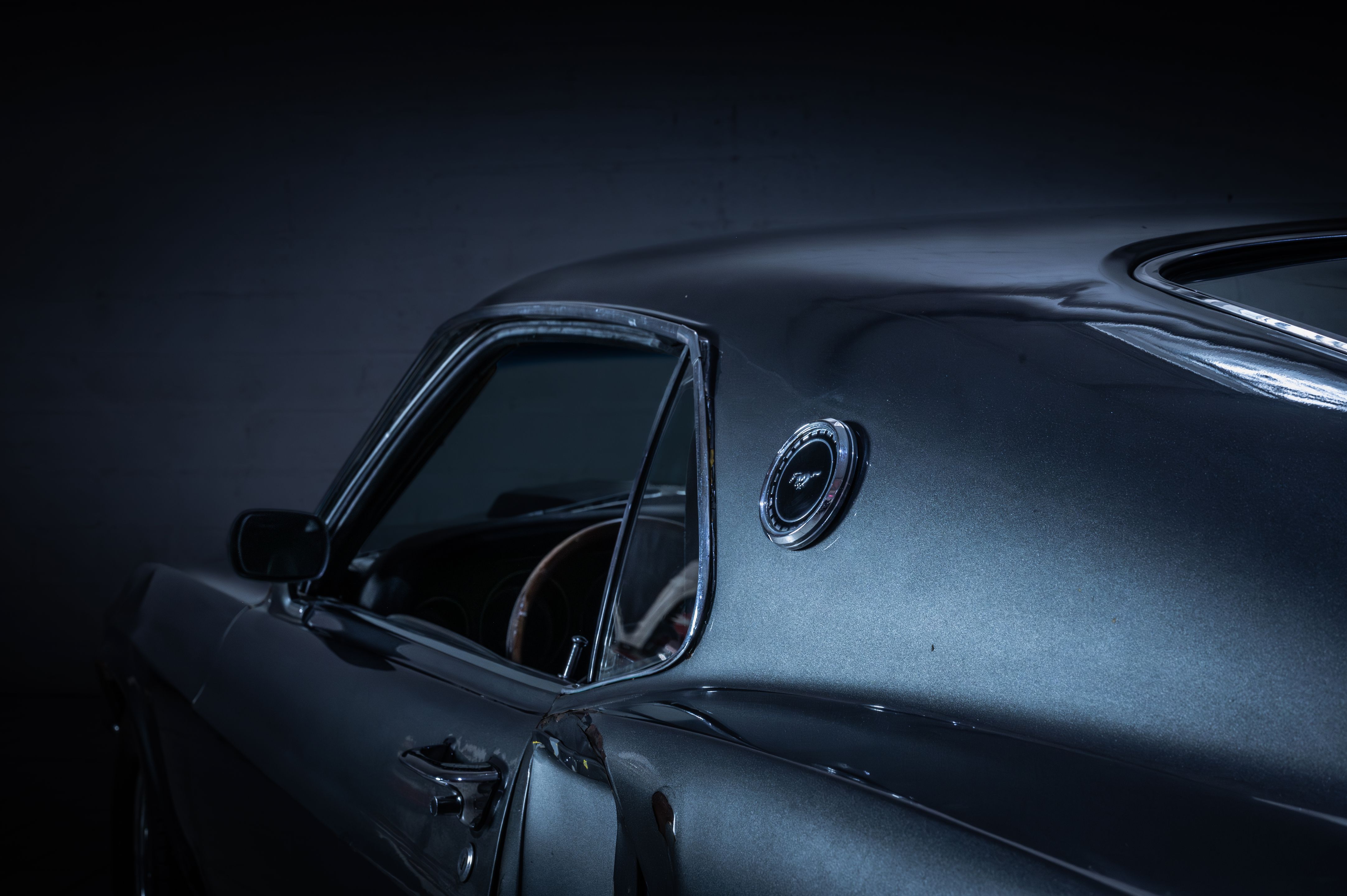 Side profile of a dark 1969 Ford Mustang styled after John Wick’s car