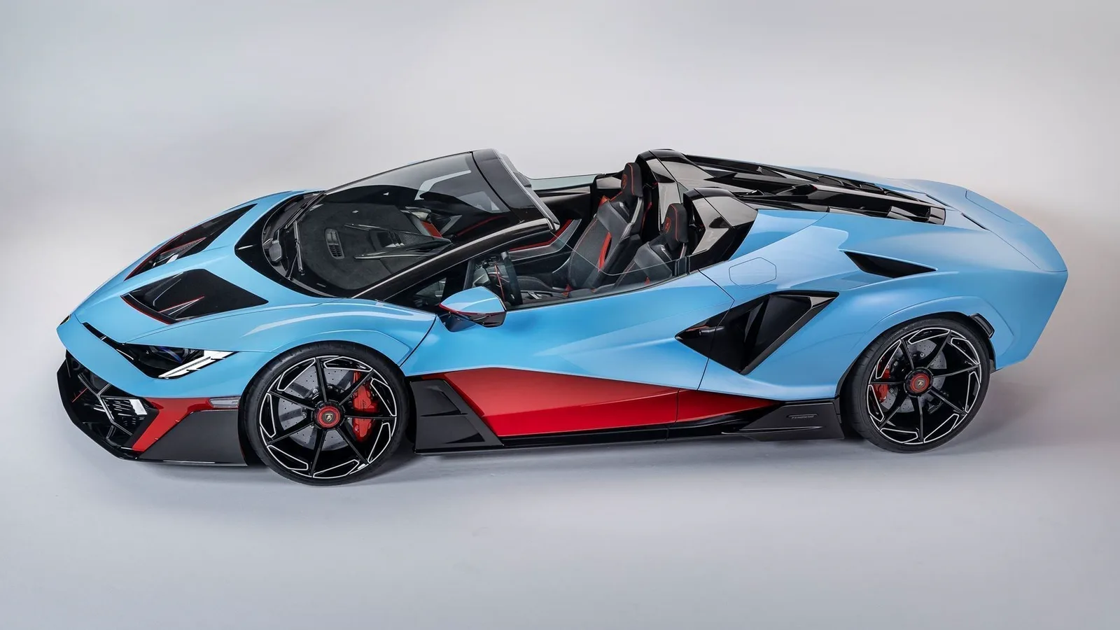 Lamborghini Fenomeno Roadster front view in Blu Cepheus paint with Rosso Mars red accents — open-top V12 hybrid Few-Off seen head-on with central Lamborghini badge and split twin-element headlights