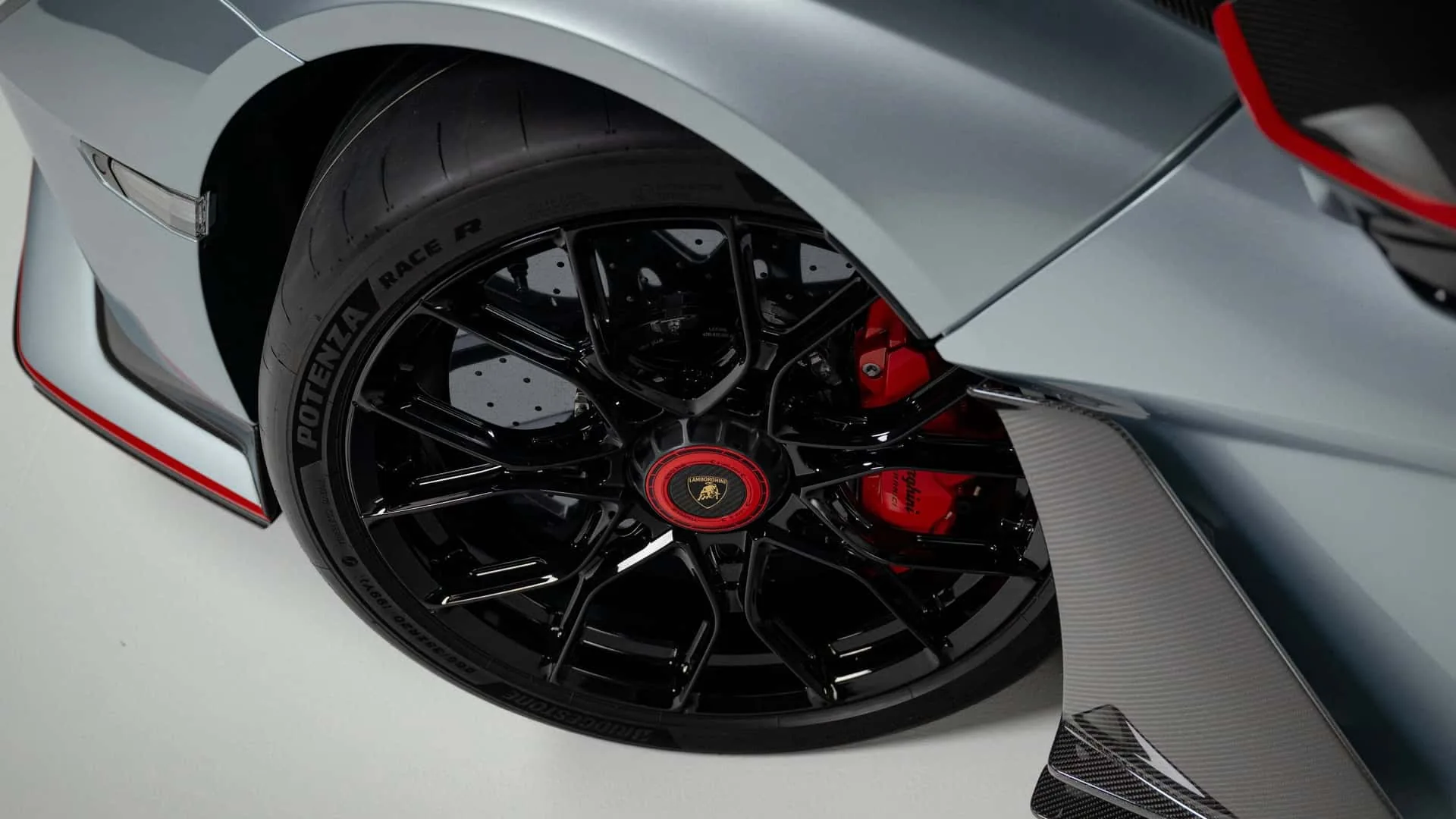 Lamborghini Revuelto SV wheel and red brake caliper close-up on carbon ceramic disc