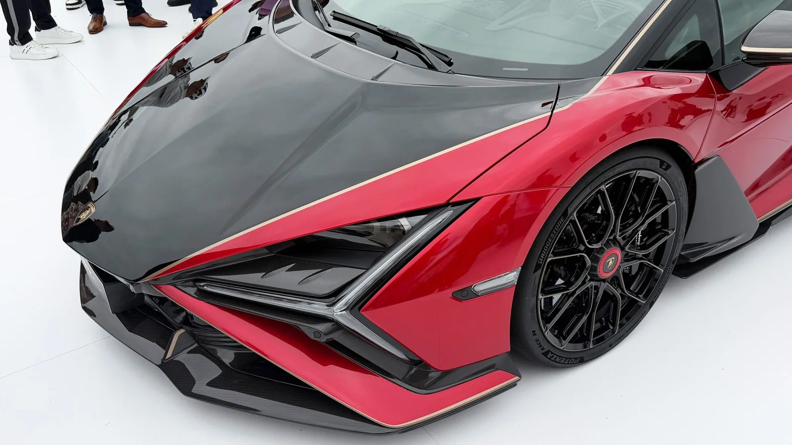 Lamborghini Revuelto SV Nera Red front end detail showing sculpted Y-signature LED headlight, black carbon splitter and forged carbon fender vent with red pinstripe outline
