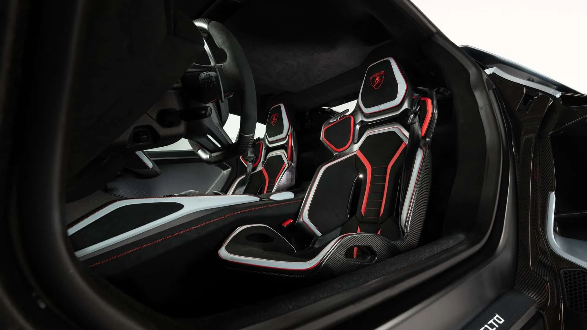 Lamborghini Revuelto SV cockpit interior with carbon fibre sports seats, red accents and driver-focused dashboard
